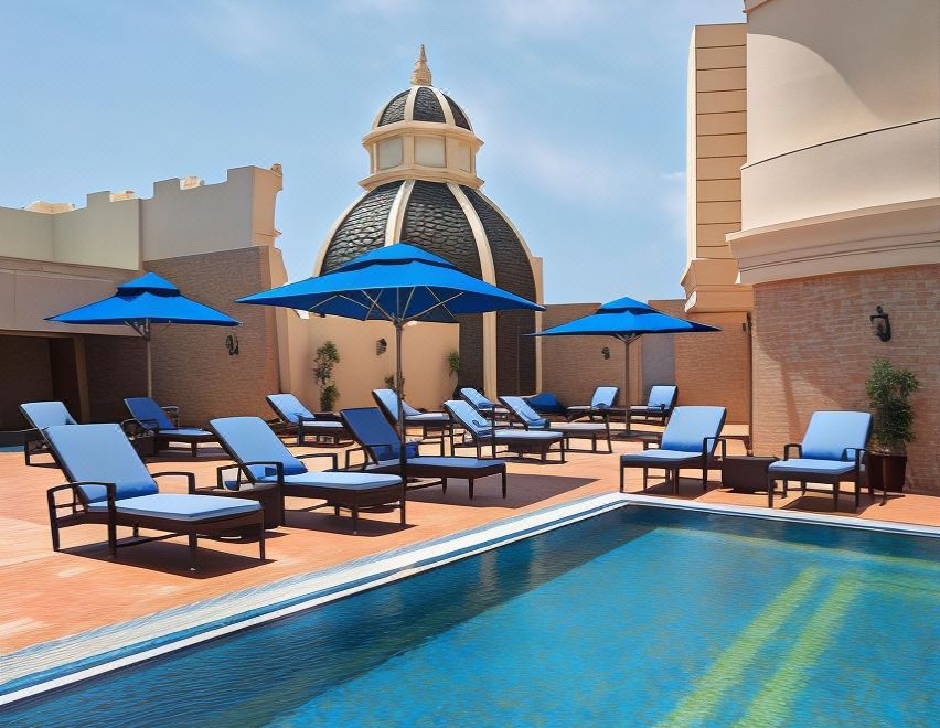 a rooftop pool surrounded by lounge chairs and umbrellas , providing a relaxing atmosphere for guests at Royal Rose Abu Dhabi, a Curio Collection by Hilton Affiliated Hotel