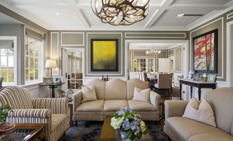 a living room with beige furniture , a chandelier , and a painting on the wall , creating a sophisticated and elegant atmosphere at Parklands Country Gardens & Lodges Blue Mountains