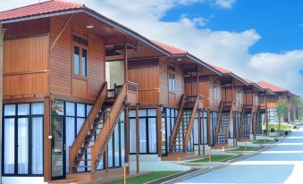 a row of wooden houses with balconies and staircases , set against a blue sky with clouds at Jsi Resort