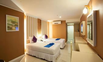 a hotel room with two beds , one on the left side and another on the right side of the room at Bay Hotel Srinakarin