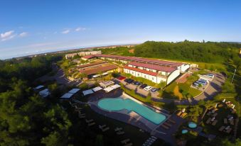 an aerial view of a large hotel complex with multiple buildings and a swimming pool , surrounded by trees at Relais Bellaria Hotel & Congressi