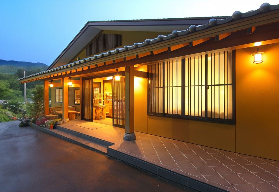 a building with a yellow roof and wooden windows is lit up at night , and the sky is cloudy at Shikimitei Fujiya