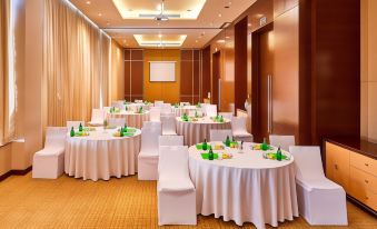 a large conference room with multiple round tables and chairs , all set up for a meeting or event at Courtyard Kochi Airport