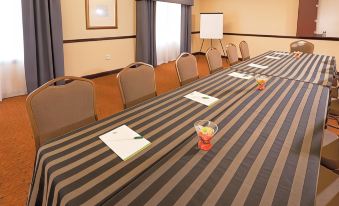 a long table with a striped tablecloth and chairs is set up in a room at Country Inn & Suites by Radisson, Baltimore North, MD