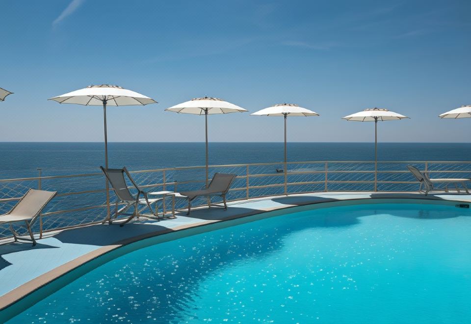 a swimming pool with lounge chairs and umbrellas overlooking the ocean , creating a relaxing atmosphere at Hotel Miramalfi