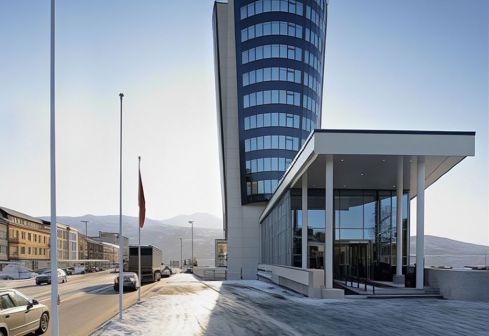 a modern building with a large glass window and a carport in front of it at Scandic Narvik