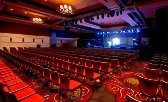 a large auditorium with rows of red chairs and a stage set up in the background at Thunder Valley Casino Resort