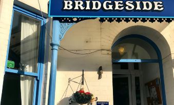 "a building with a blue and white sign that reads "" bridgeside "" on the front" at Bridgeside Guest House
