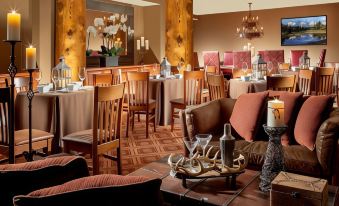 a cozy dining room with wooden furniture , a couch , and a dining table filled with plates and cutlery at The Lodge at Jackson Hole