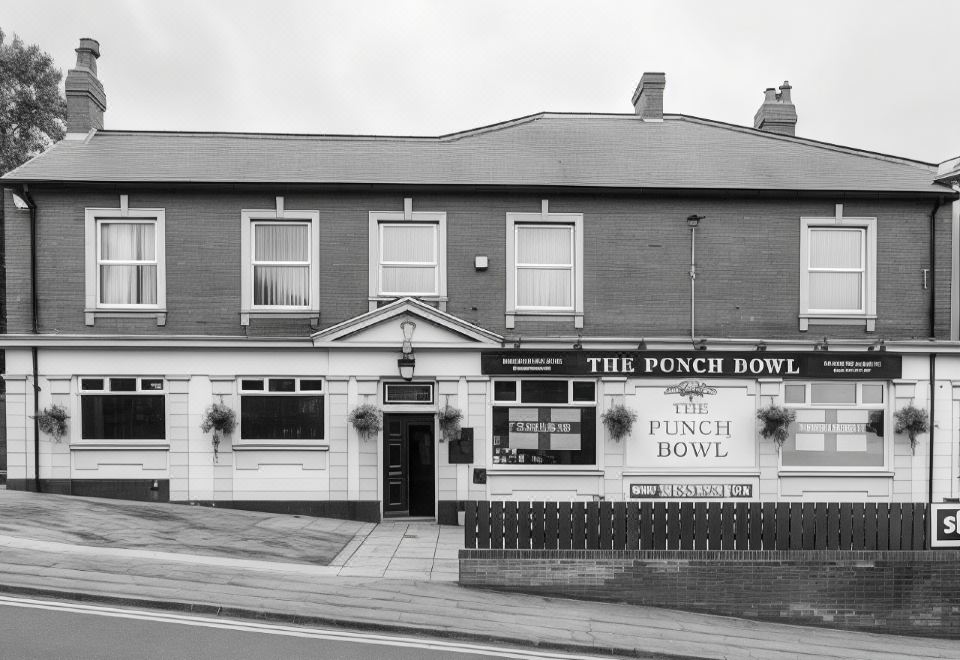 a black and white photo of the punch bowl pub , located in a residential area at The Punch Bowl