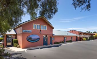 "a large building with a blue sign that reads "" big blue whale hostel "" is shown" at Swansea Motor Inn Tasmania