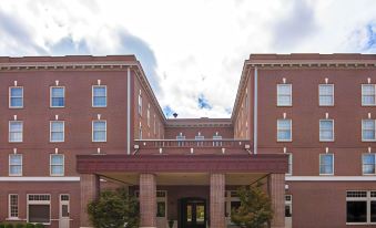 a large brick building with multiple stories and balconies , located in a residential area at Liberty Hotel, Ascend Hotel Collection