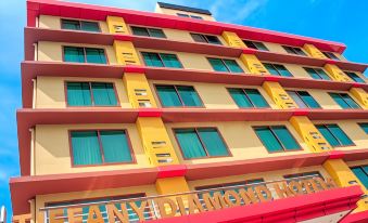 "a yellow building with red trim and windows is shown against a blue sky , with the words "" paradise penty diamond - me "" written below" at Tiffany Diamond Hotels - Mtwara