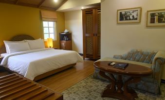 a hotel room with a bed , nightstand , and desk , along with wooden furniture and artwork at The Richmond