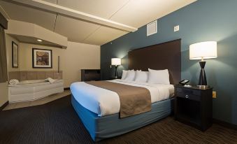 a large bed with a blue headboard is in the middle of a room with brown and white linens at AmericInn by Wyndham Mounds View Minneapolis