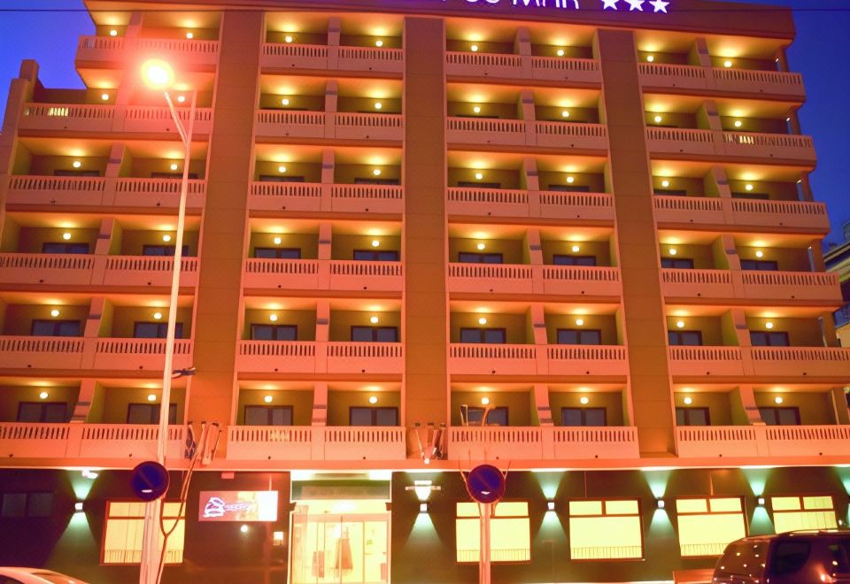 a large hotel with multiple floors and balconies , lit up at night , on a city street at Hotel Vent de Mar
