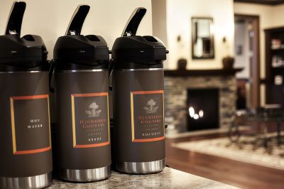 "two brown thermos bottles with the label "" bloomingdale 's "" are sitting on a counter in front of a fireplace" at Country Inn & Suites by Radisson, Watertown, SD