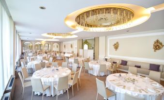 a large dining room with round tables and chairs arranged for a formal event , possibly a wedding reception at Blue Dream Hotel