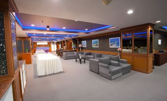 a large , empty conference room with multiple couches and chairs arranged in a seating area at Bay Hotel Srinakarin