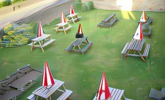 a grassy area with several picnic tables and umbrellas set up in a park - like setting at Duke of Wellington