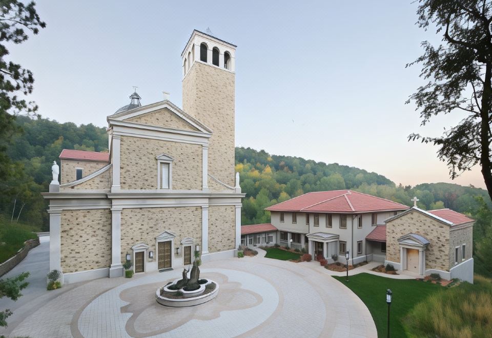 a large stone building with a church tower and a fountain in front of it at Justin Trails Resort