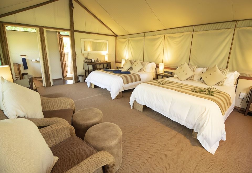 a room with two beds , one on the left side and the other on the right side of the room at Tembe Elephant Park