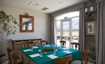 a dining room with a table set for a meal , surrounded by chairs and a large window at Parador de Las Canadas del Teide
