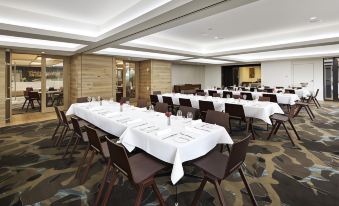a large dining room with multiple tables and chairs arranged for a formal event , possibly a banquet at Flinders Hotel