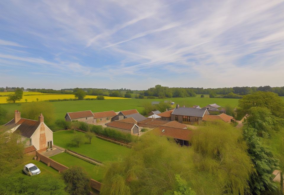a bird 's eye view of a large , well - maintained estate with multiple buildings and green fields at Retreat East