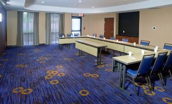 a conference room with blue carpeting , white tables , and chairs , a large screen on the wall , and two doors at Courtyard Ontario Rancho Cucamonga