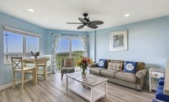 a living room with a blue wall , a couch , a dining table , and a television at Ocean Pointe Suites at Key Largo