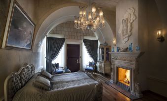 a large bedroom with a bed , chandelier , and an arched doorway leading to a fireplace at Sacred House