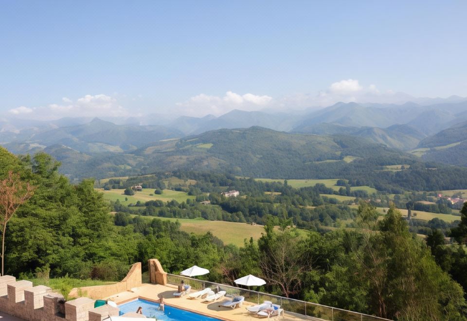 a large swimming pool is surrounded by lounge chairs and umbrellas , with a view of mountains in the distance at Hotel Cerro La Nina