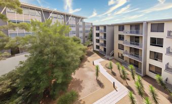 an aerial view of a modern apartment building surrounded by trees and a courtyard , with a clear blue sky in the background at Oaks Sydney North Ryde Suites