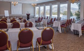 a conference room set up for a meeting , with tables and chairs arranged in rows at White Mountain Hotel and Resort