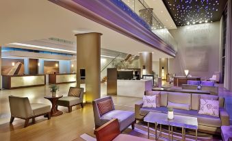 a modern lounge area with comfortable seating , a bar , and a staircase leading to the second floor at Hilton Windhoek