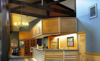 a modern kitchen with wooden beams , a dining area , and a bar area in the background at The Inn at Silvercreek