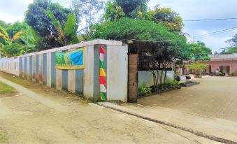 a house with a colorful mural on the side of it , surrounded by trees and bushes at Bakom Inn Syariah