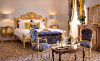 a luxurious bedroom with a large bed , a chair , and a table in the room at Hotel Saint-Martin - Younan Collection