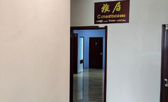 a hallway with a white wall and brown door , leading to a room with a large window at Comfort Inn