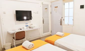 a hotel room with two beds , a desk , and a tv , all neatly arranged in the room at Victoria Bed & Breakfast