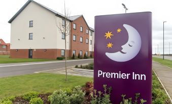 a sign for premier inn in front of a brick building , with the logo of the hotel prominently displayed at Thirsk