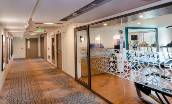 a hallway with a blue and white patterned carpet , large glass doors , and a wooden floor at Holiday Inn Express Kolkata Airport