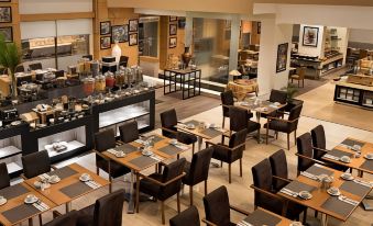 a large dining room with tables and chairs arranged for a group of people to enjoy a meal together at Aryaduta Palembang