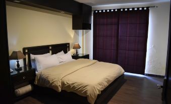 a bed with a white comforter and pillows is in a room with wooden floors at Summit Hotel