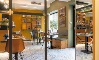 a modern , stylish restaurant with yellow walls and wooden furniture , featuring a dining table , chairs , and various decorative items at Avenue Boutique Hotel