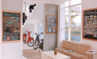 a cozy living room with white walls , a coffee table , and a bicycle parked outside at Tani Jiwo Hostel