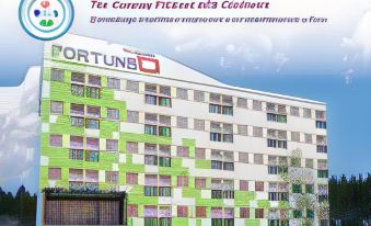 "a colorful building with the name "" fortuna "" on it , surrounded by trees and other buildings" at Fortune D Hotel Loei