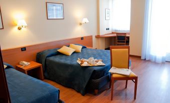 a hotel room with two beds , a desk , and a chair , all neatly arranged in the space at Hotel Touring