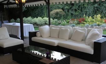 a white couch and a glass table are on a patio overlooking a garden at Blue Dream Hotel